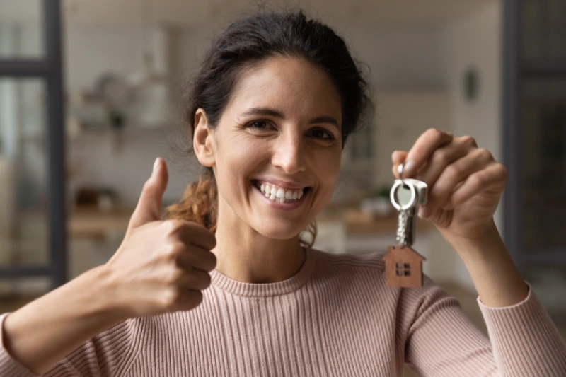 woman giving a thumbs up holding a house key